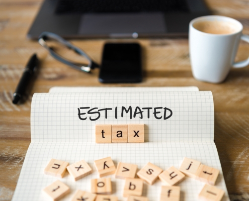 figuring estimated tax with blocks, notebook, and coffee