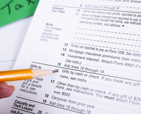 pencil in hand pointing to a list of itemized deductions on a tax form