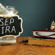 SEP IRA written on a jar of money on a table with books and glasses