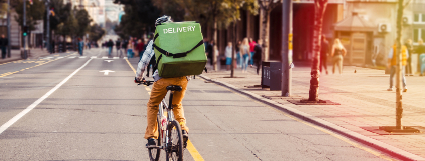 a gig worker riding his bike to a delivery