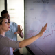 businessman and businesswoman looking at a graph on a screen