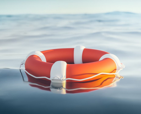 orange life raft floating in water
