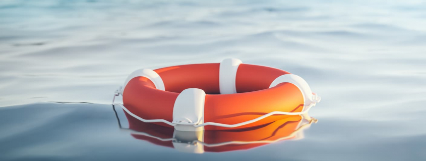 orange life raft floating in water