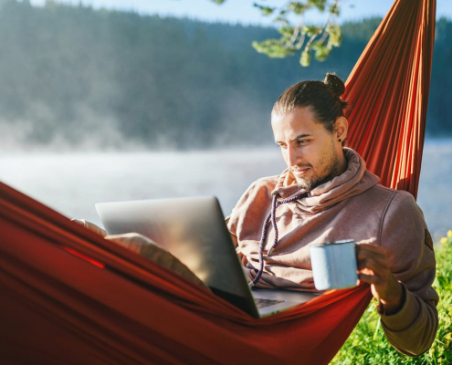 self-employed worker in a hammock with computer and coffee