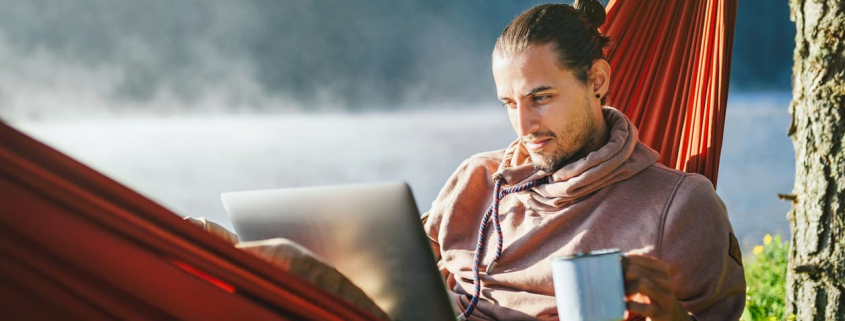 self-employed worker in a hammock with computer and coffee