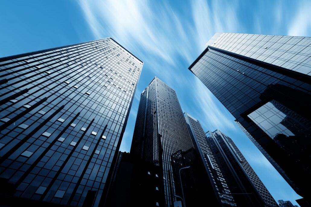 Looking up at modern office buildings under a blue sky