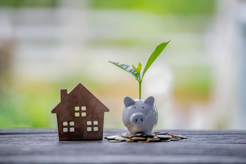 Piggy bank with a growing plant beside a house symbol, representing estate tax planning in 2026 for high-income earners